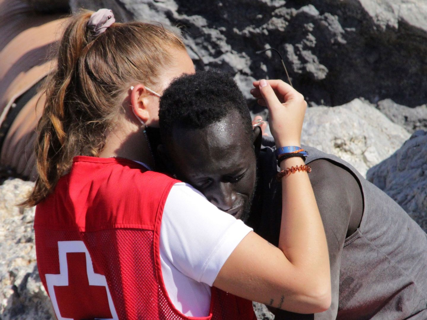 Una trabajadora de Cruz Roja abraza a un migrante que ha logrado llegar a Ceuta (EFE)
