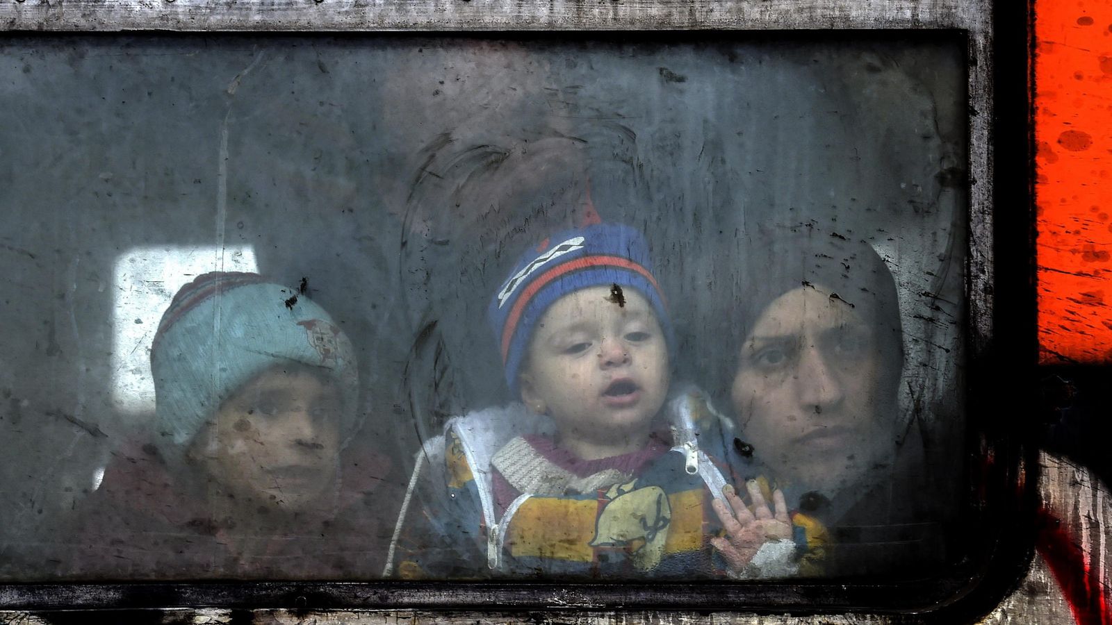 Foto: Un familia de refugiados mira a través de la ventana del tren antes de partir hacia a la frontera serbia. (EFE)