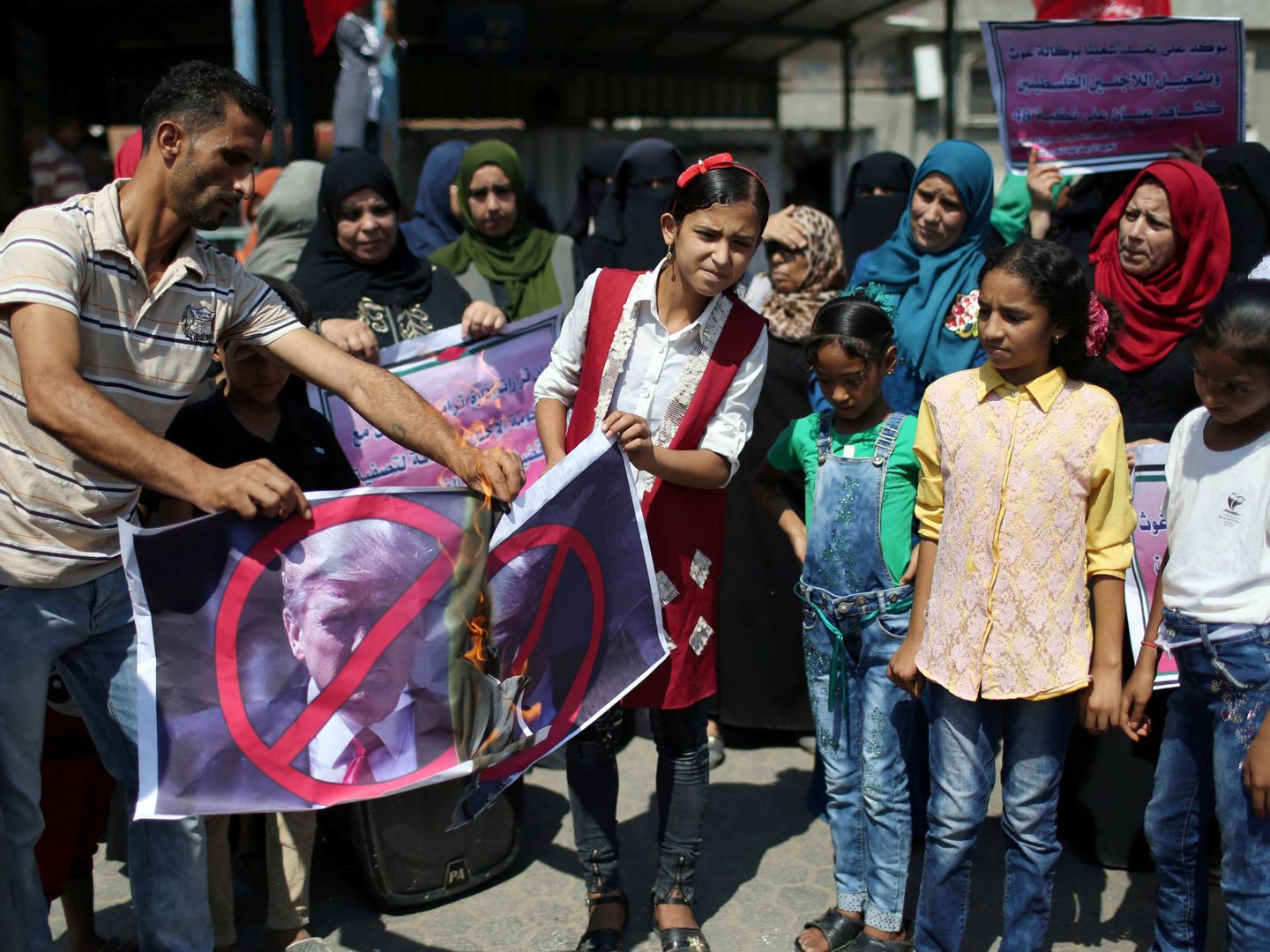 Niñas palestinas queman un retrato de Donald Trump durante una protesta contra la cancelación de fondos de la UNRWA, en Gaza, el 11 de septiembre de 2018. (Reuters)