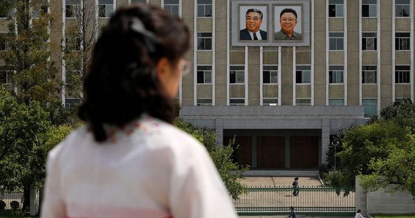 Foto: Una mujer frente a los retratos de los fallecidos líderes norcoreanos Kim Il-sung y Kim Jong-il en una fachada en Pyongyang, en septiembre de 2018. (Reuters)