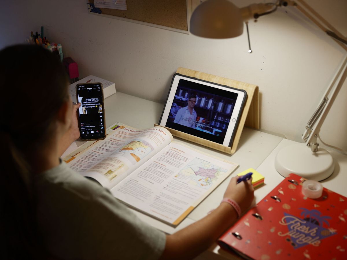 Foto: Una adolescente realiza "deberes" junto a una tableta y un teléfono móvil. (EFE/Luis Tejido)