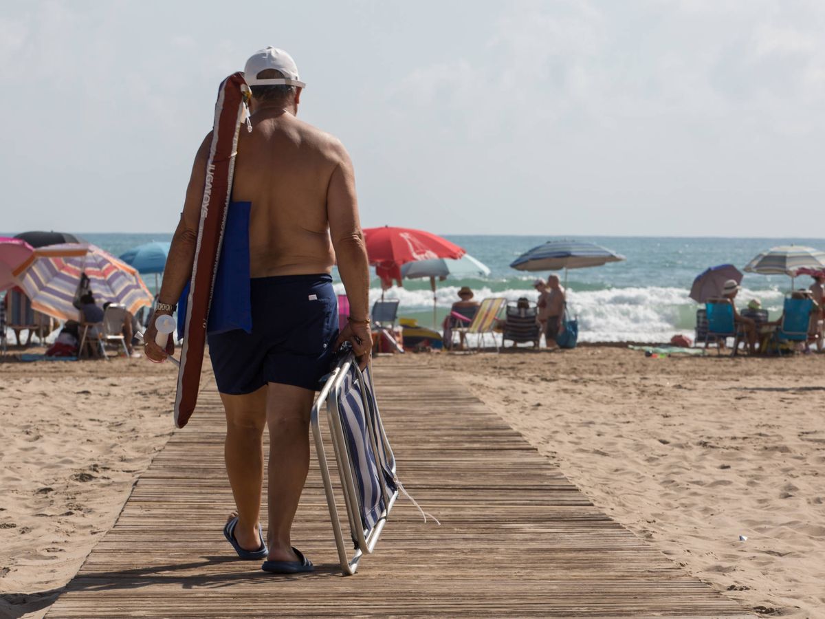 Foto: Un turista accede a la playa de Gandía (Valencia). (David Brunat)