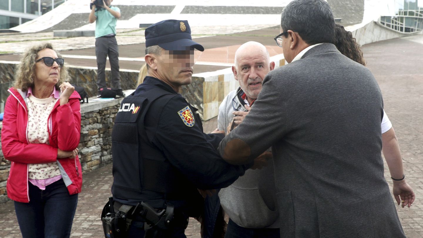 Una persona es interceptada por la policía por propinar un pequeño golpe al ex jefe de Seguridad de Adif, Andrés Cortabitarte. (EFE/ Xoán Rey)