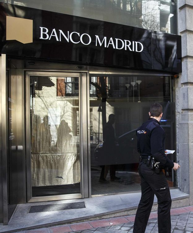 Foto: Un agente ante una sucursal de Banco Madrid. (Reuters)