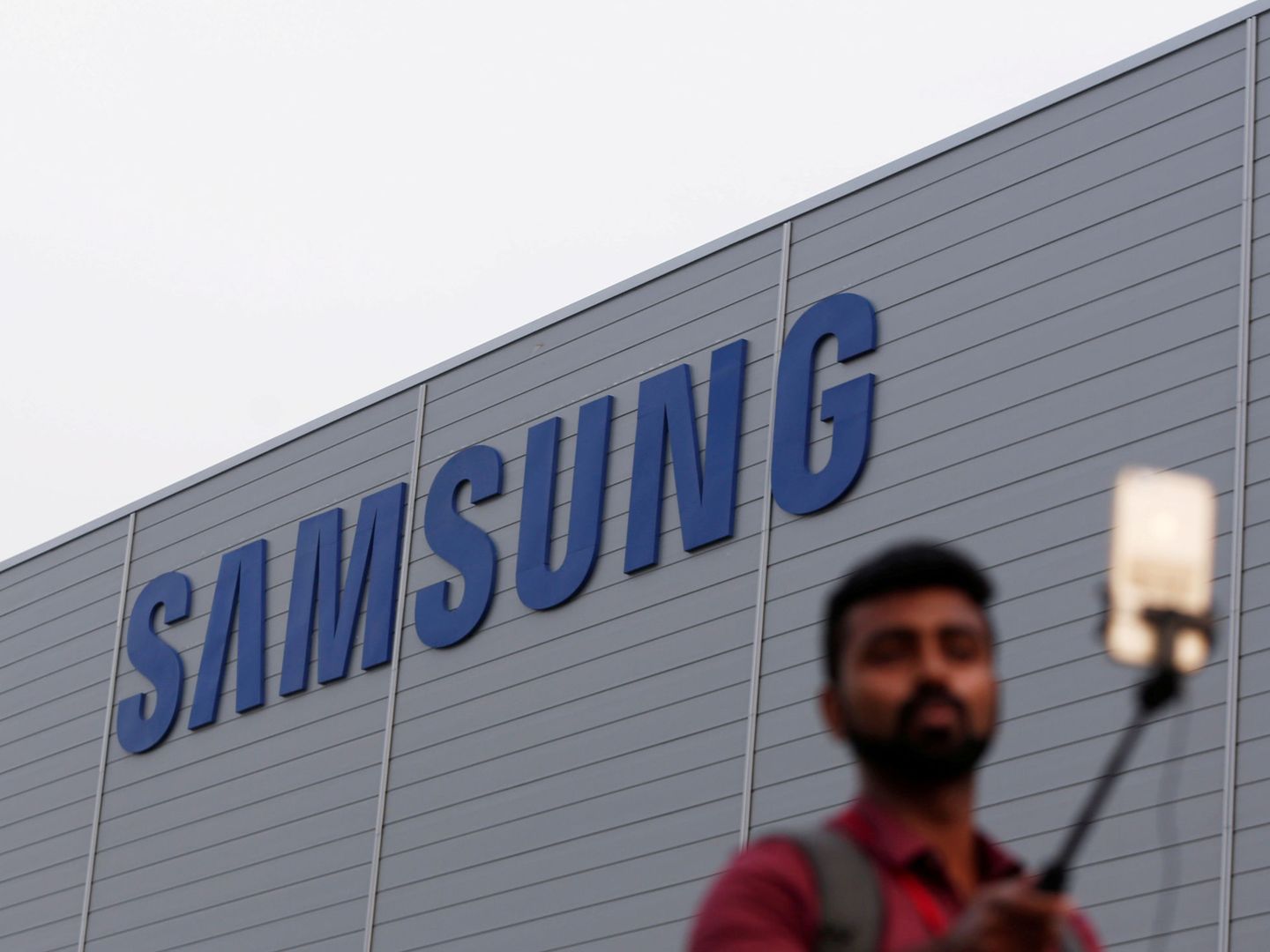 Un joven indio se fotografía frente a una fábrica de Samsung en el país asiático. (Reuters)