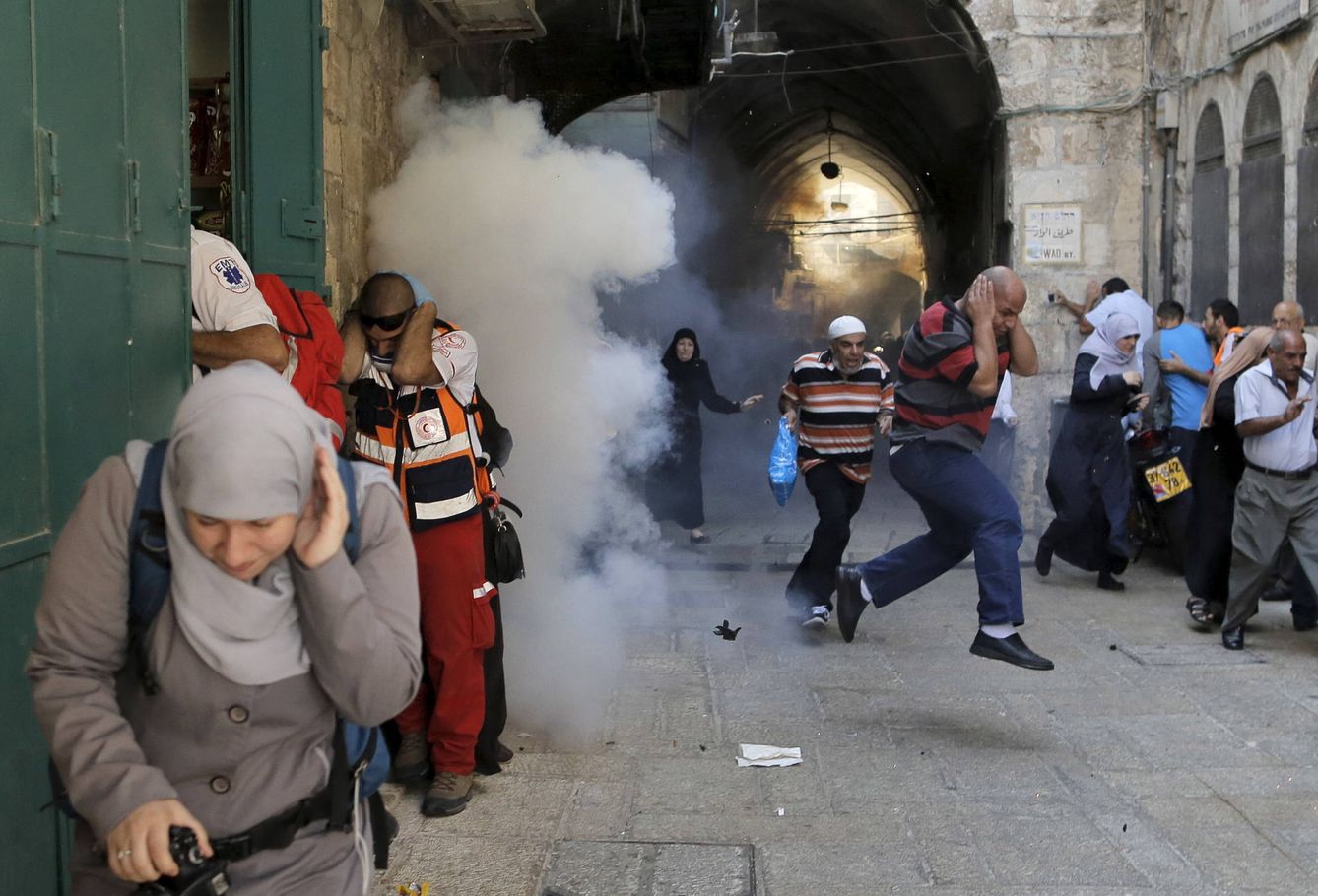 Manifestantes palestinos corren tras el estallido de una granada de sonido lanzada por la policía israelí en la Ciudad Vieja de Jerusalén, el 28 de septiembre de 2015. (Reuters)