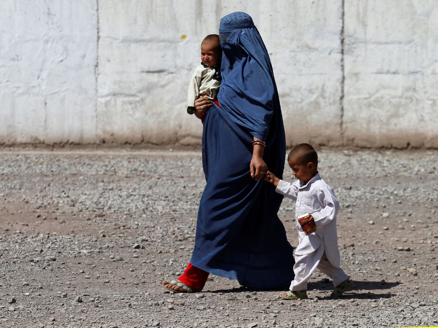 Una mujer afgana, camina hacia la frontera con sus dos hijos | Reuters