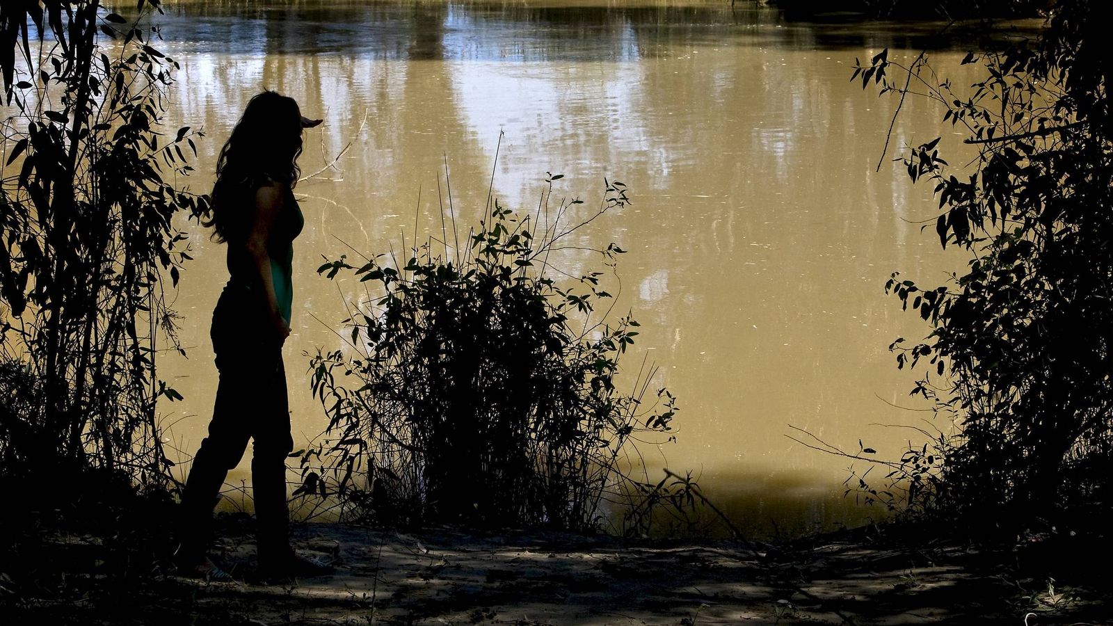 Foto: Una joven observa el caude del Guadiamar a su paso por la localidad de Aznalcóllar. (EFE)