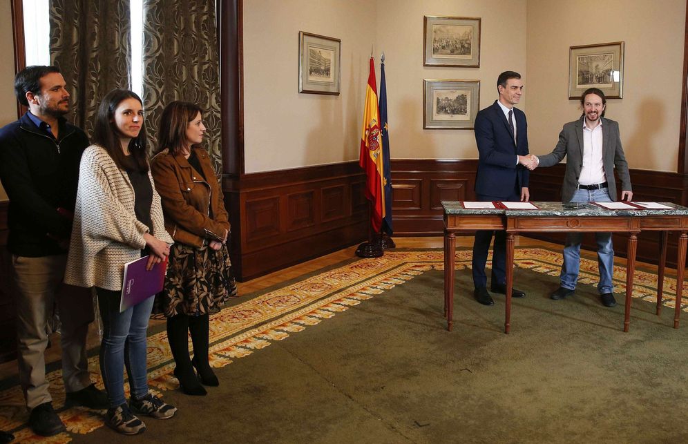 Foto: Pedro Sánchez y Pablo Iglesias firman el acuerdo ante la mirada de Adriana Lastra, Irene Montero y Alberto Garzón, este 12 de noviembre. (EFE)
