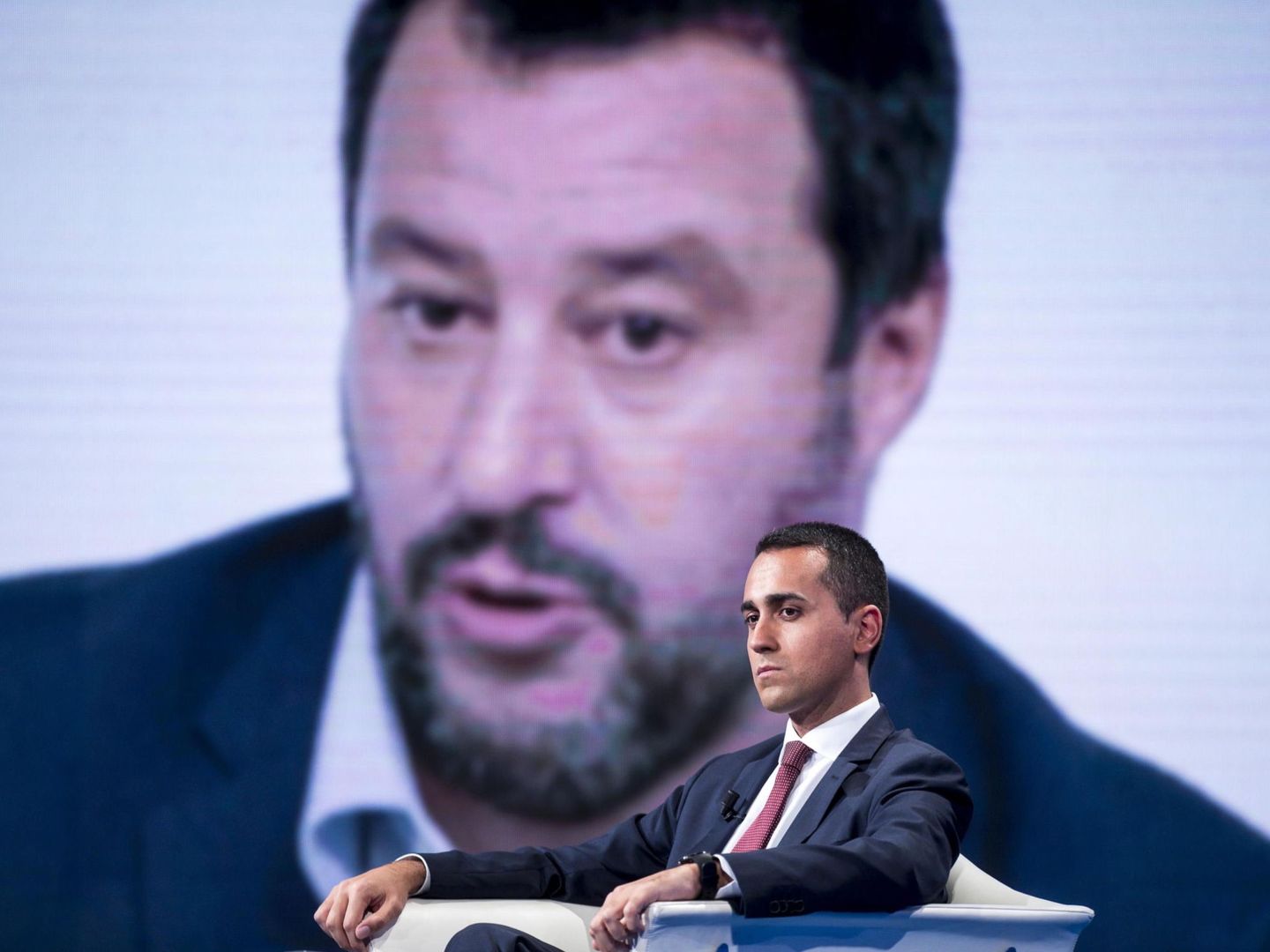 Luigi di Maio, líder de M5S, frente a una foto de su socio de gobierno, Salvini (EFE)