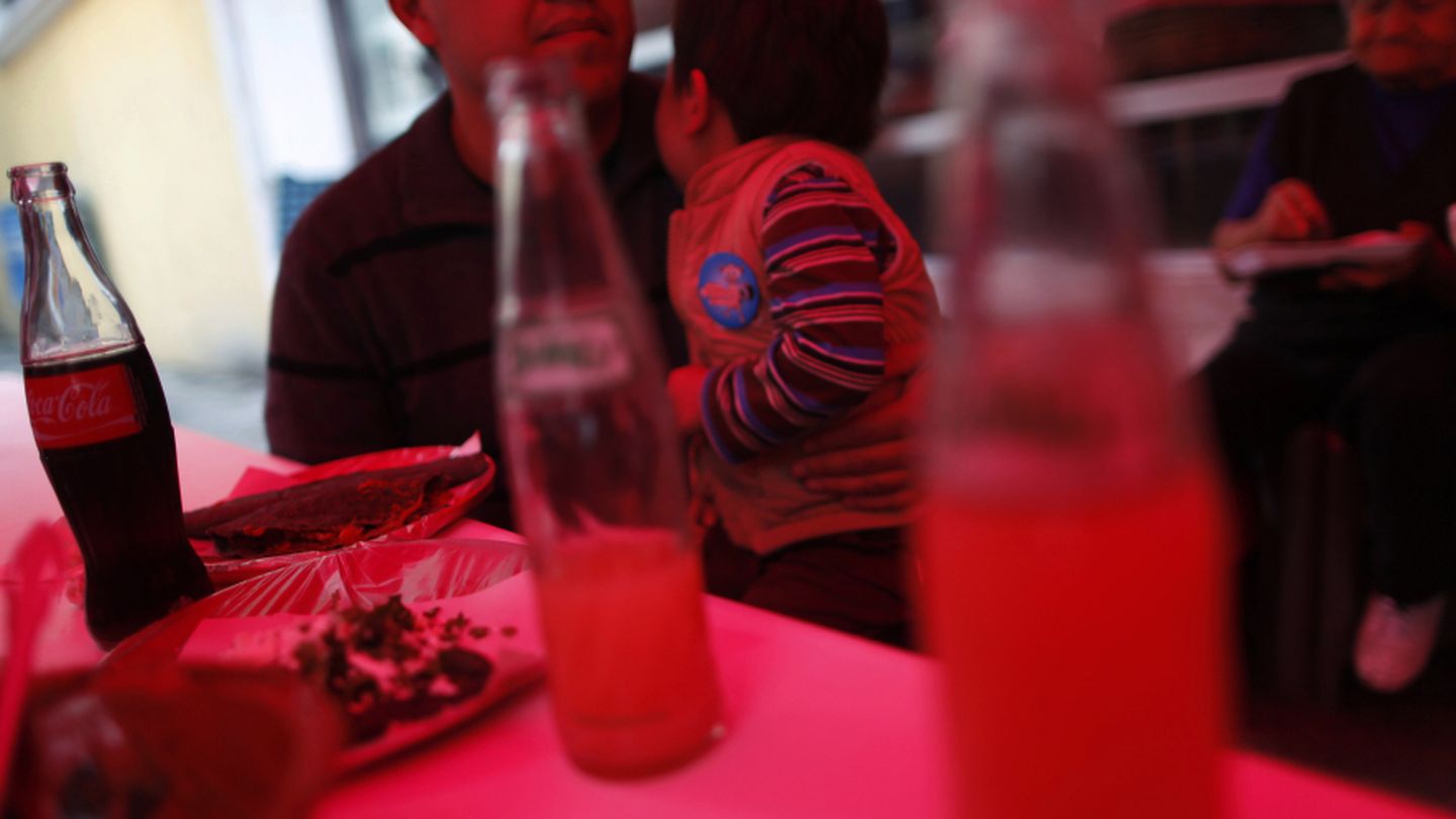 Un hombre come con su hijo en un puesto callejero de comida en Ciudad de México (Reuters).