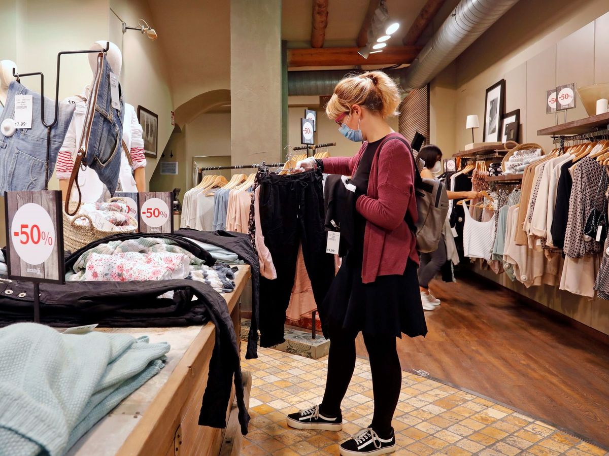 Foto: Una clienta observa unas prendas de ropa en una tienda (EFE)