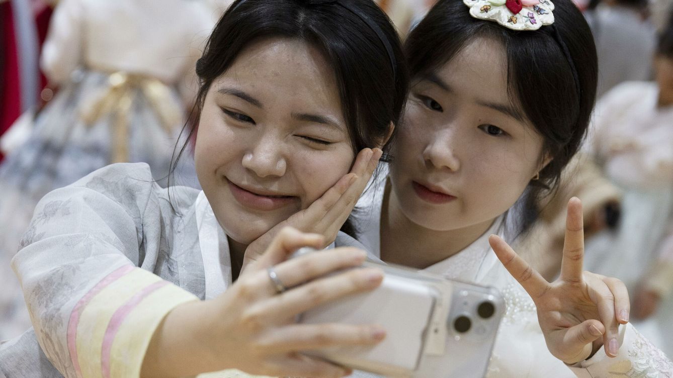 Foto: Graduadas con trajes tradicionales coreanos se toman un selfi durante su ceremonia de graduación. (EFE/Jeonn Heon-Kyun)