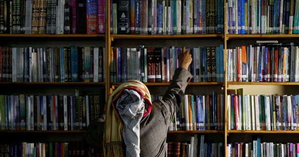 Foto: El autor yemení Mohammed al-Qaoud coge un libro de su biblioteca en Sanaa (Reuters)
