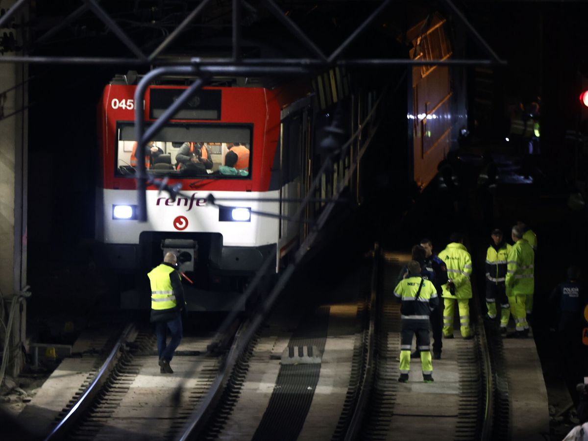 Foto: Operarios trabajan en el tren de Cercanías descarrilado el pasado día 5. (EFE/Sergio Pérez)