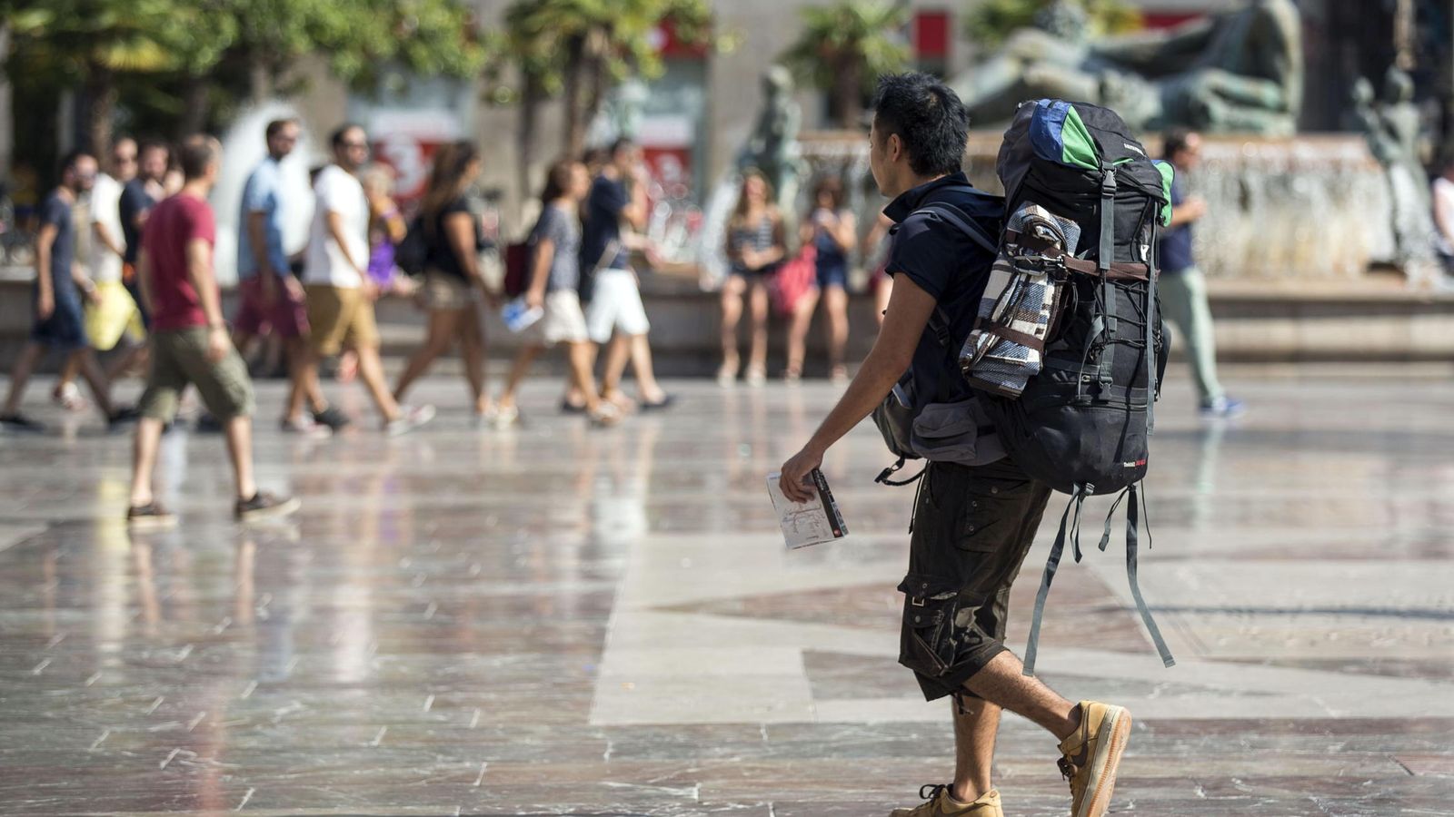 Foto: Un turista con mochila camina por la plaza de la Virgen de Valencia. (EFE) 