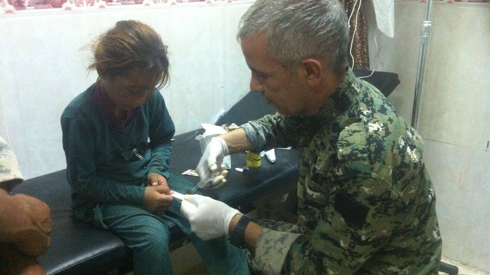 Foto: El "Doctor Delil" atiende a una niña yadizí en un clínica de campaña de las YBS.
