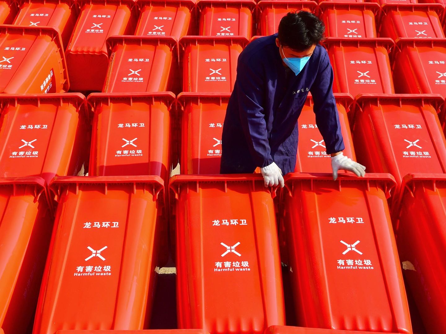 Un trabajador traslada contenedores con productos sanitarios en Ganzhou, China. (Reuters)