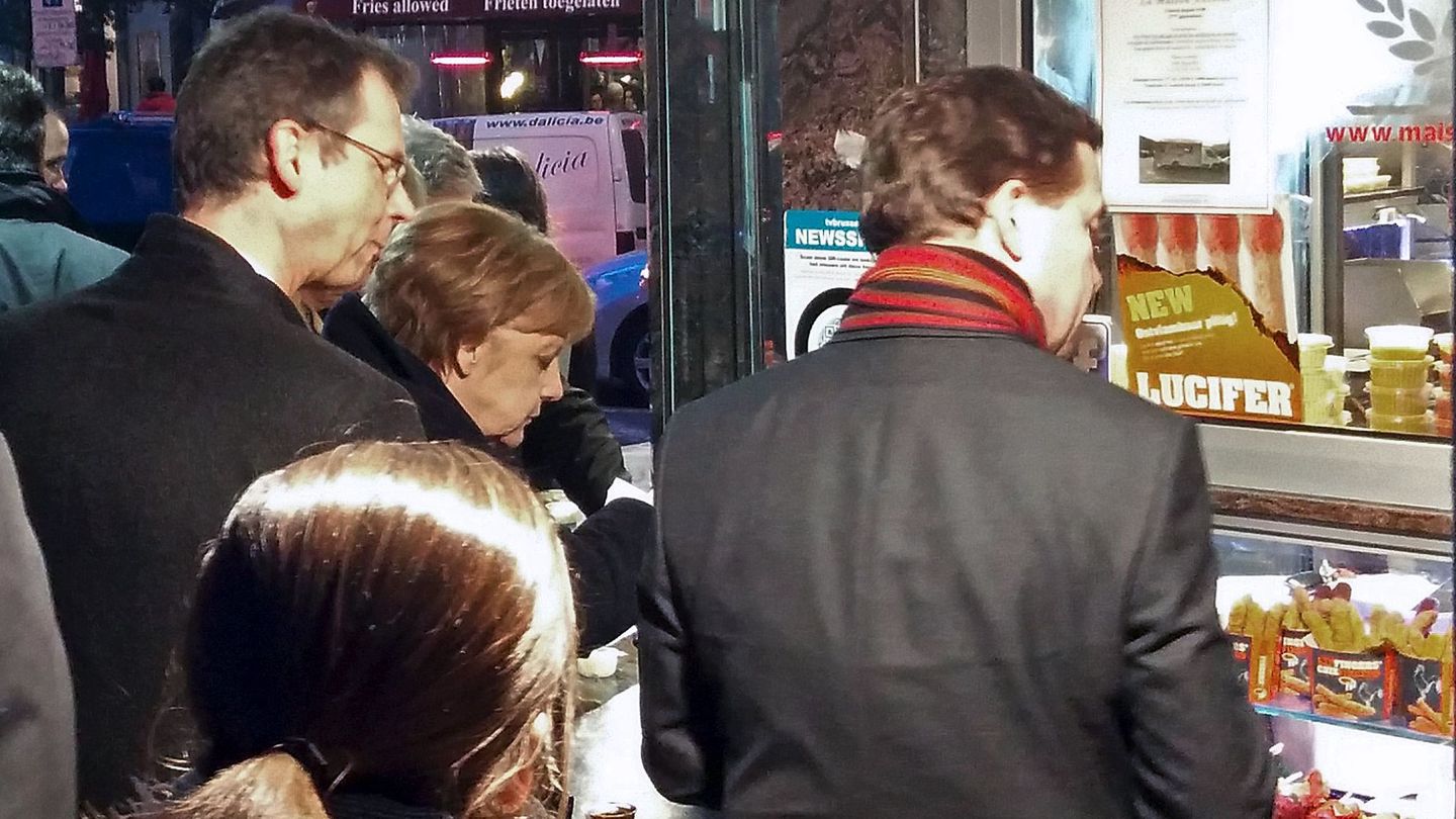 Merkel compra patatas fritas en una popular 'friterie' del barrio europeo de Bruselas. (Reuters)
