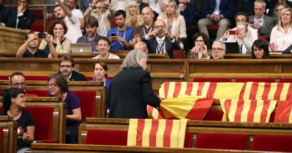 Foto: La diputada de Catalunya Sí Que Es Pot Àngels Martínez retira las banderas de España de los escaños del PPC, este 6 de septiembre. (EFE)