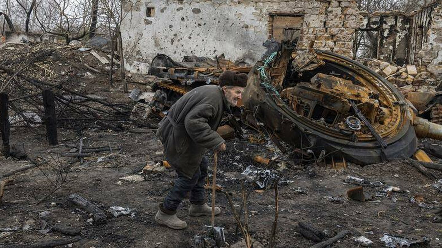   Oleksii Shcherbo, de 98 años, pasa por delante de su casa destruida y los restos de un tanque ruso en el poblado de Sloboda, cerca de Chernígov. (Reuters/Marko Djurica)