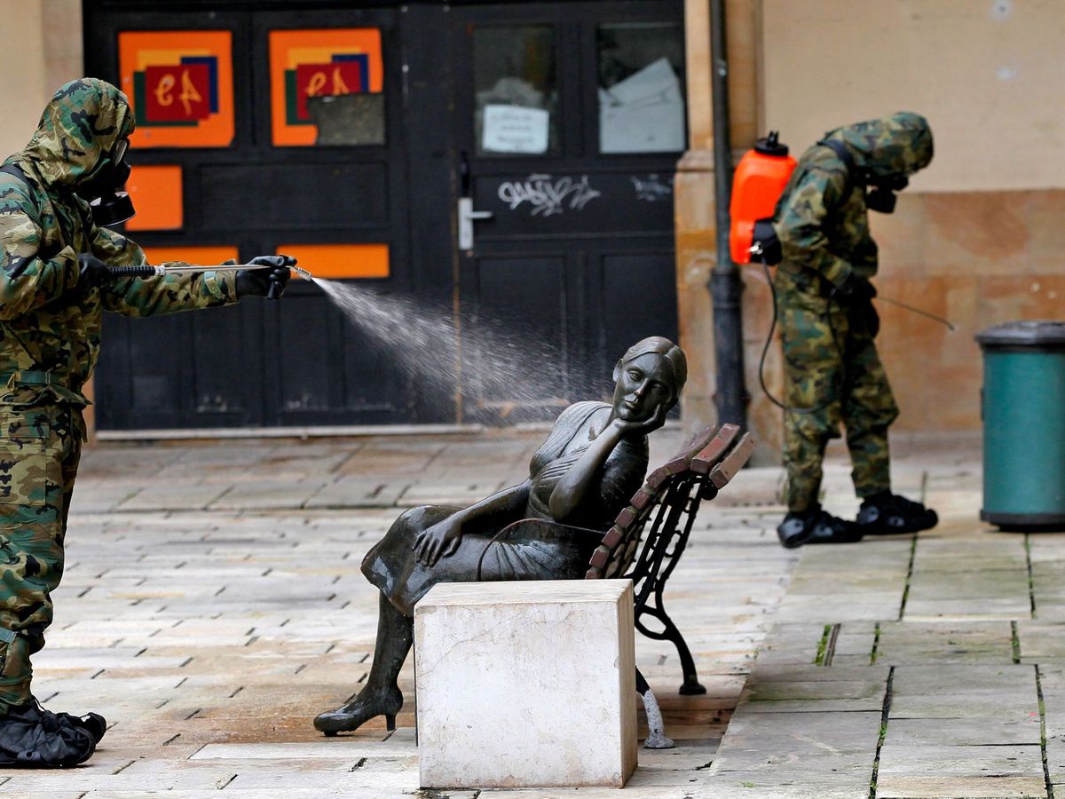 Foto: Un soldado desinfecta una escultura en una de las plazas del mercado del Fontán, en Oviedo, para combatir la propagación del coronavirus. (EFE)