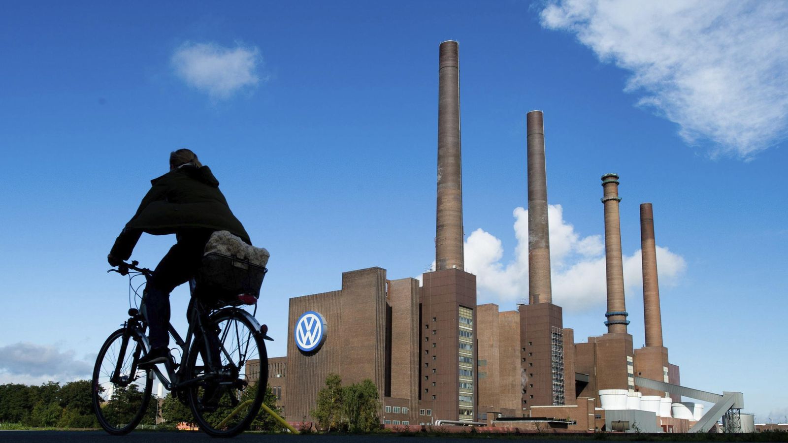 Foto: Un ciclista pasa por delante de la planta de Volkswagen en Wolfsburg, Alemania. (EFE)
