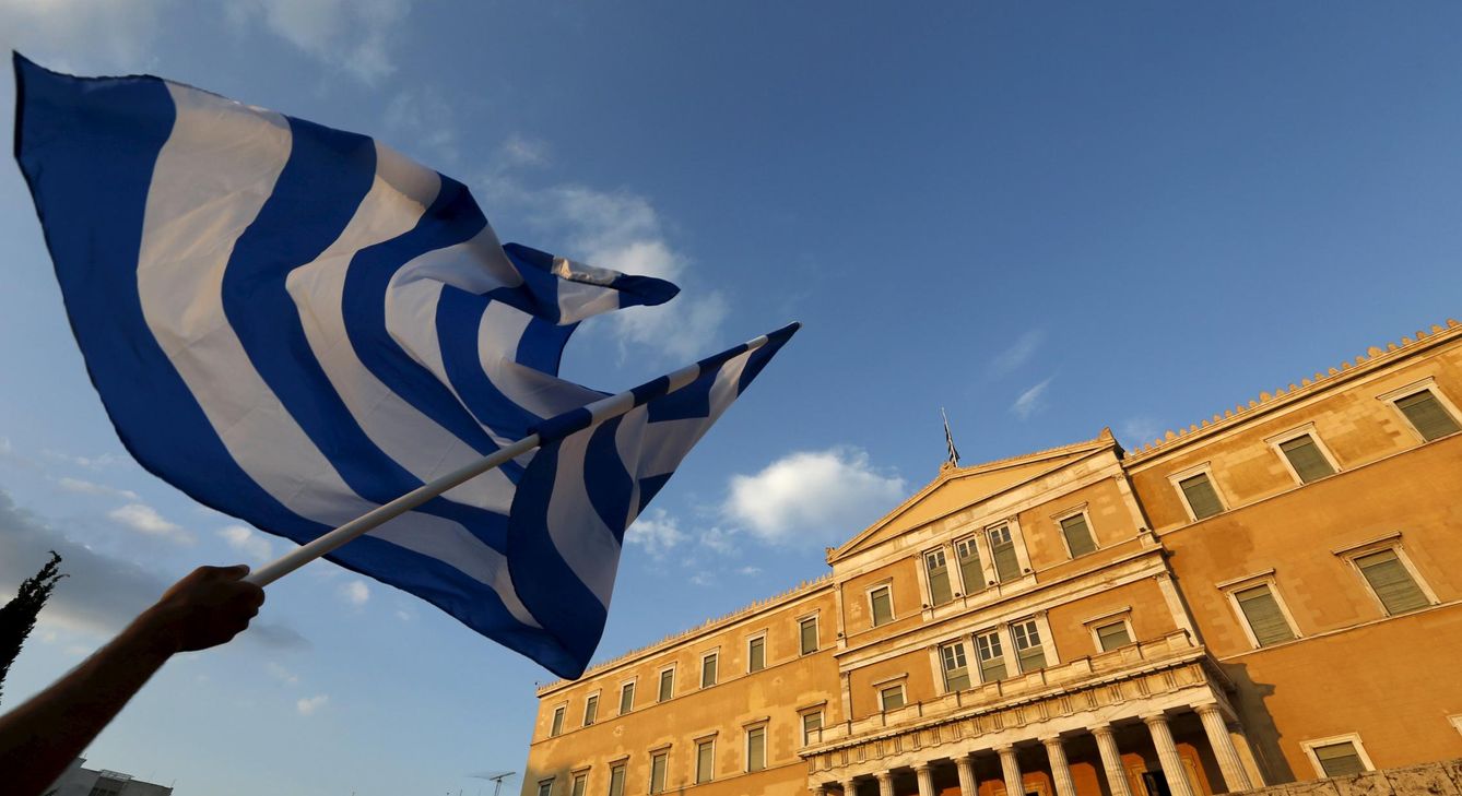 Un manifestante ondea la bandera griega frente el Parlamento heleno. (Reuters)