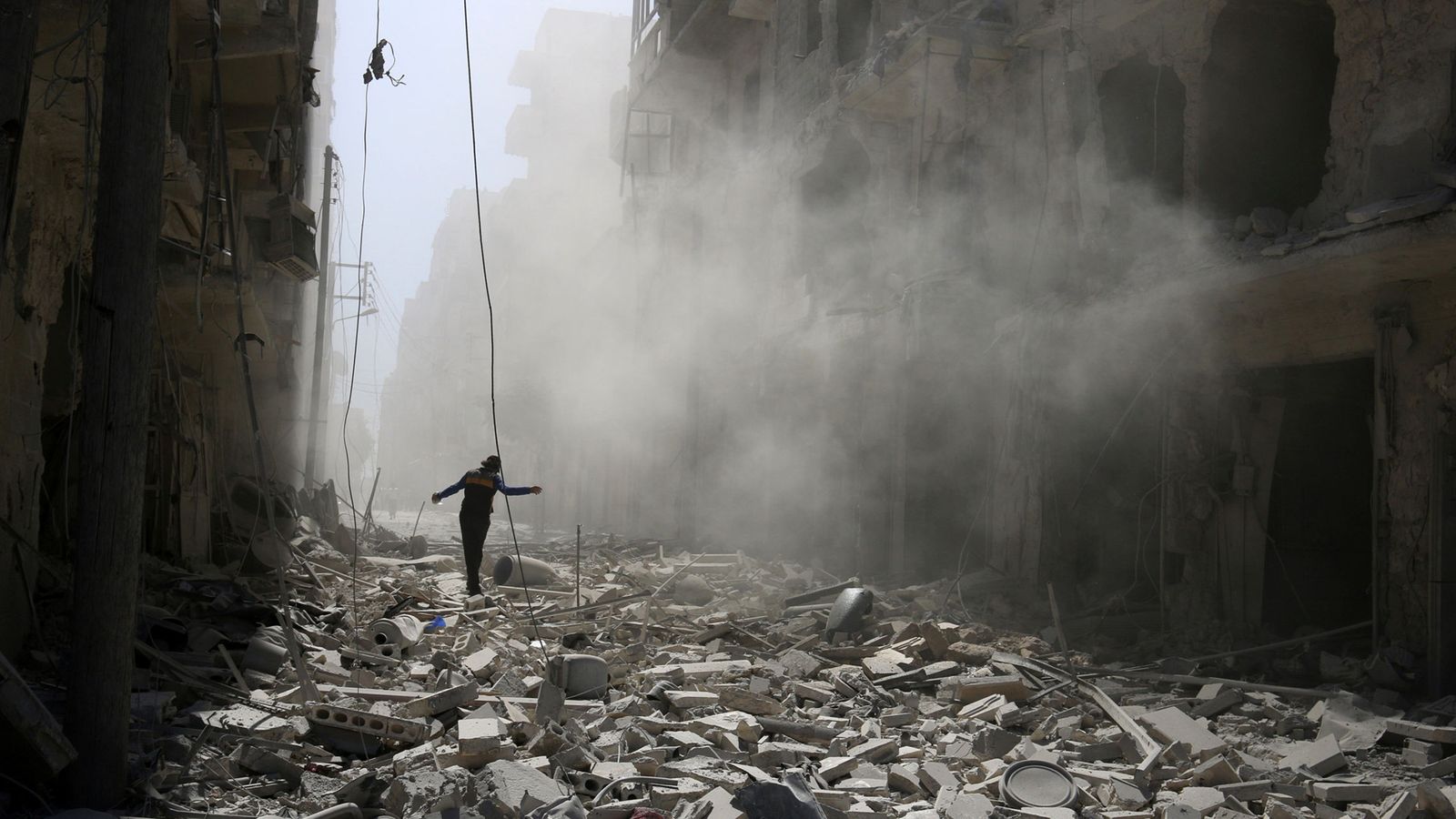 Foto: Un hombre camina sobre las ruinas de un barrio de Alepo, en Siria. (Reuters)