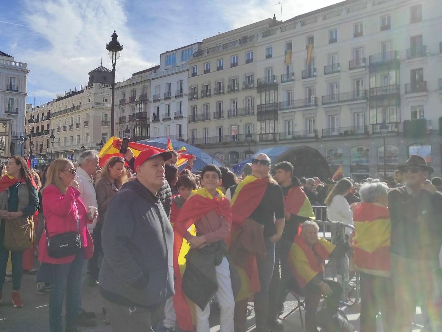 Varias personas concentradas en la Puerta del Sol, de Madrid, antes del discurso de Feijóo. (L.B.)