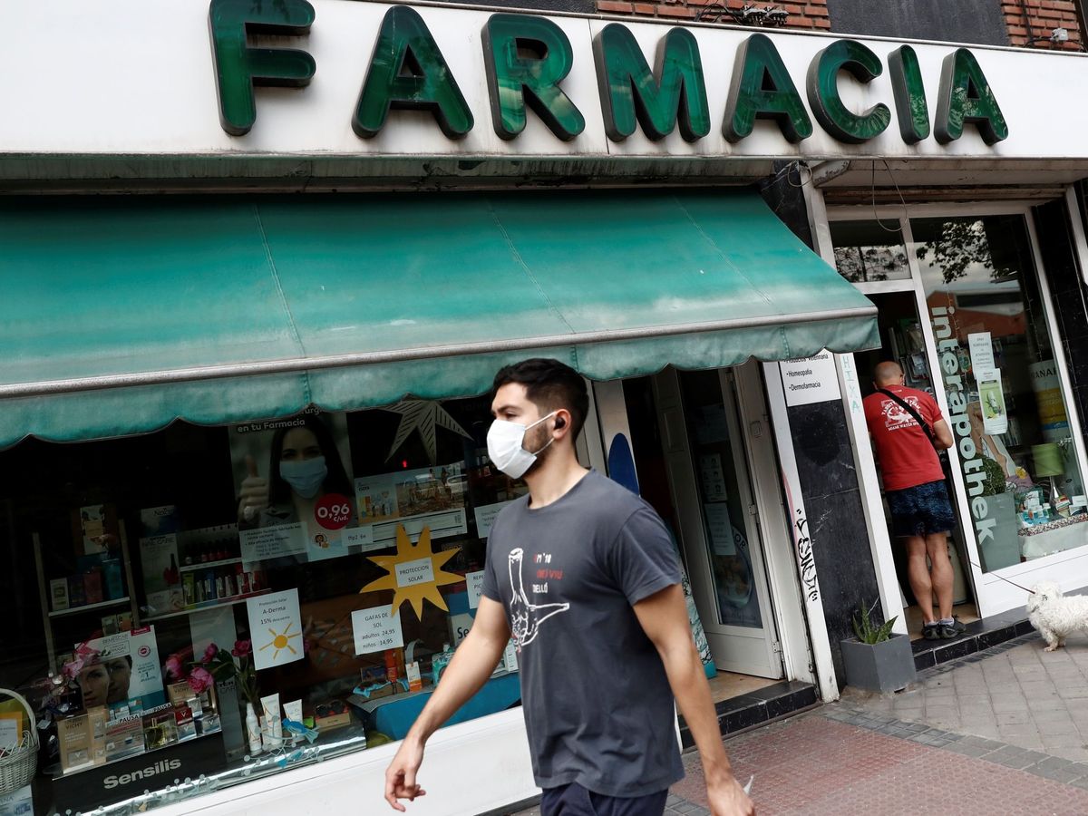 Foto: Un hombre con mascarilla pasa delante de una farmacia en Madrid, el pasado 3 de junio. (EFE)
