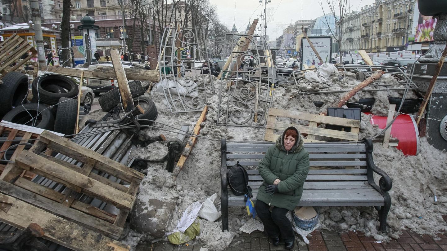 Una mujer ucraniana, sentada ante una barricada en el centro de Kiev (Reuters).
