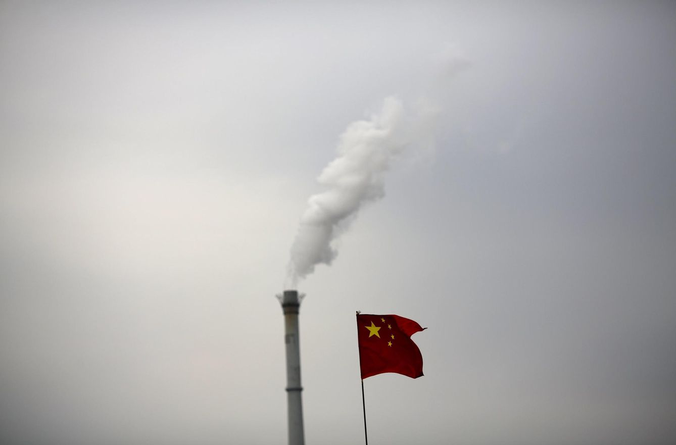 Una bandera china junto a la chimenea de una planta de cogeneración en Pequín. (Reuters)