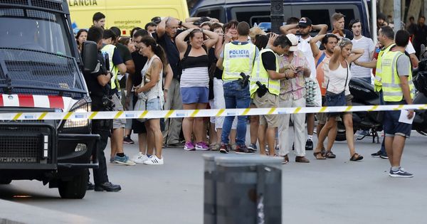 Foto: Un grupo de gente con los brazos en alto ante el despliegue policial en el lugar del atentado. (EFE)