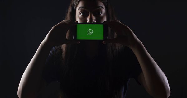 Foto: Una mujer sostiene un móvil con el logotipo de WhatsApp. (Unsplash)