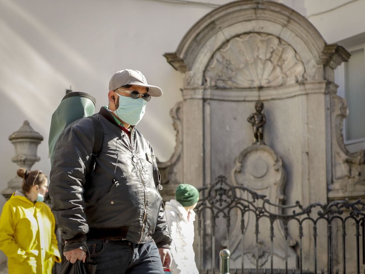 Foto: Un hombre con una mascarilla pasea por Bruselas. (EFE)