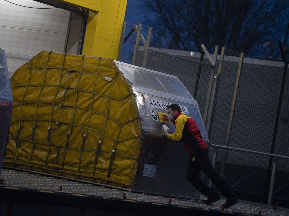 Foto: Un empleado empuja un contenedor con 25.000 vacunas de Pfizer-BioNTech en el aeropuerto de Sofía, Bulgaria.