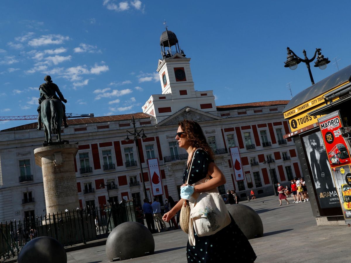 Foto: Una mujer pasea por la Puerta del Sol en Madrid en el verano de 2021. (Reuters) 