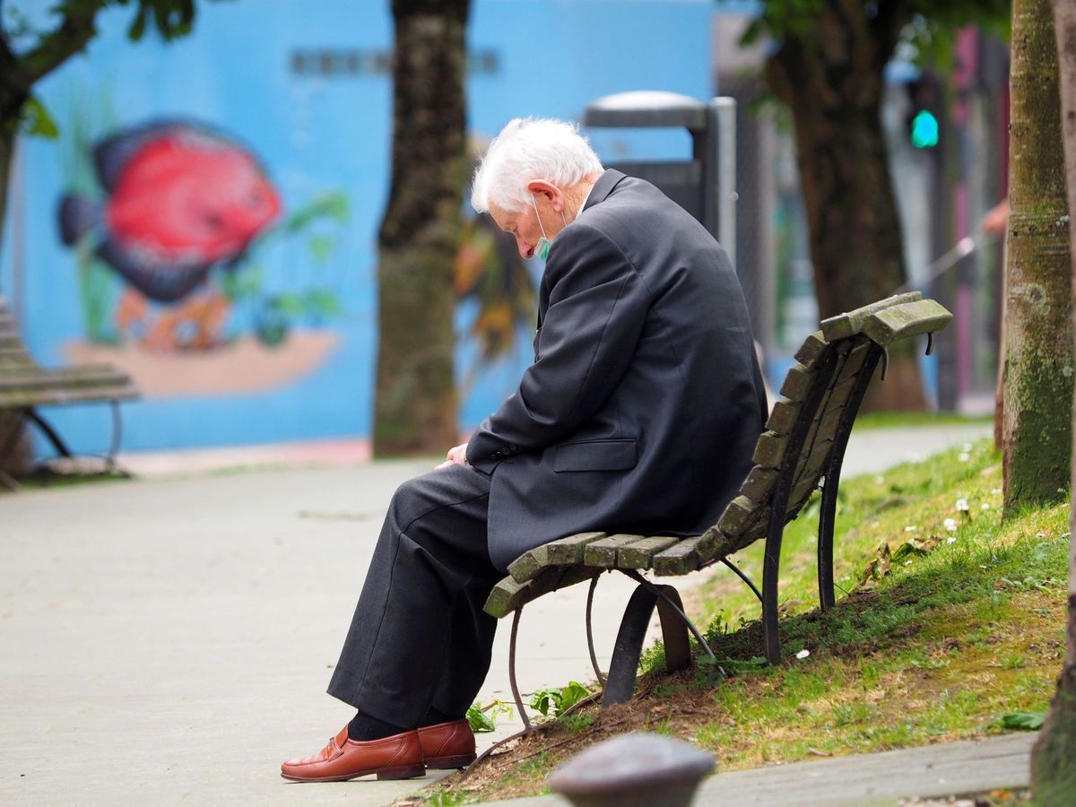 Foto: Un anciano descansa sentado en un banco de la avenida Fontiñas, en Lugo. (EFE/Eliseo Trigo)