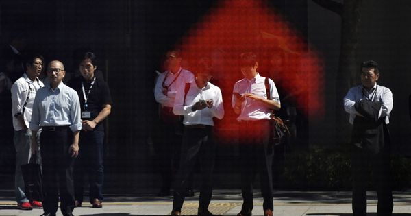 Foto: Peatones se reflejan en un cuadro indicador del mercado bursátil en Tokio (Japón). (EFE)
