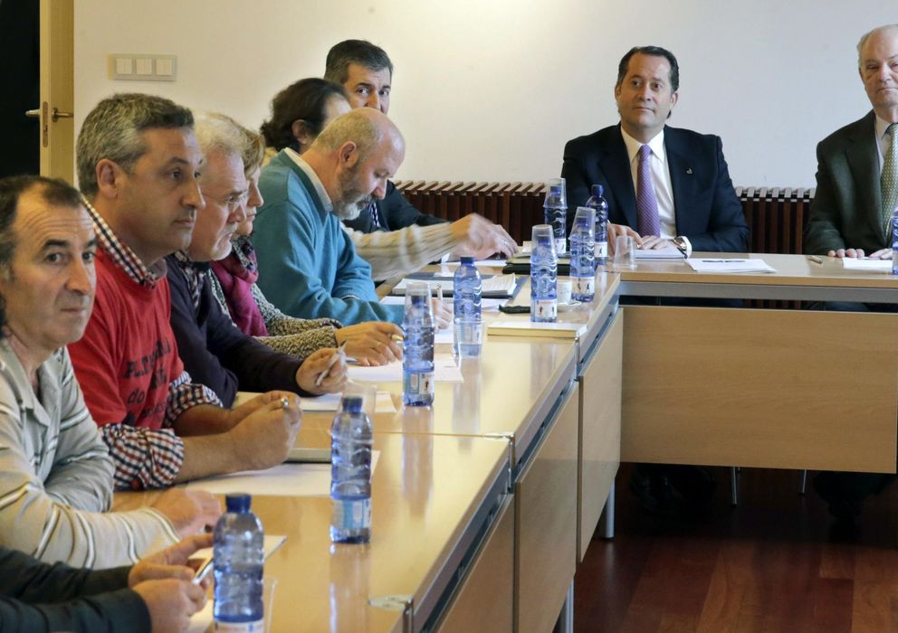 Foto: Juan Carlos Escotet (2d) y Javier Echeverría (d), durante la reunión con una representación de las plataformas de afectados por las preferentes. (EFE)