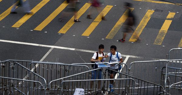 Foto: Dos hombres consultan un mapa junto a una de las barricadas construidas en las protestas de Hong Kong, 2014. (Reuters)