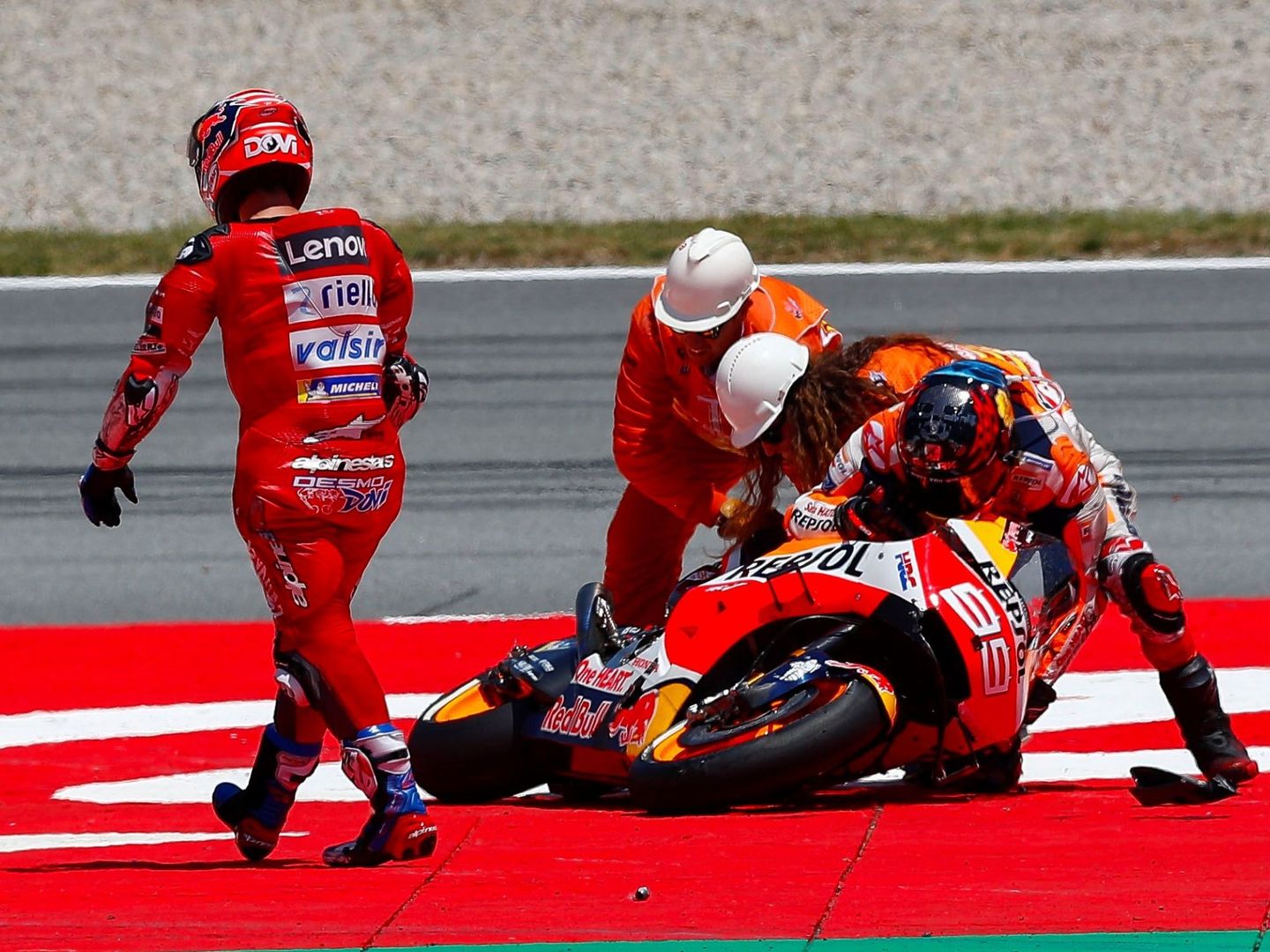 Jorge Lorenzo trata de levantar su moto tras la caída en el GP de Catalunya. (EFE)