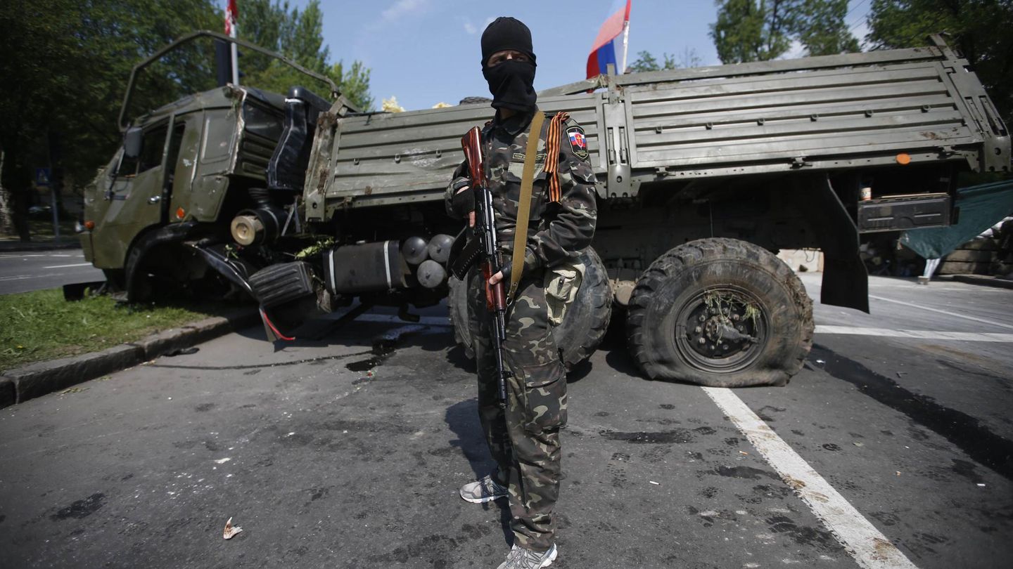 Un combatiente de la milicia Ejército Ortodoxo Ruso ante un camión prorruso atacado en Donétsk (Reuters). 