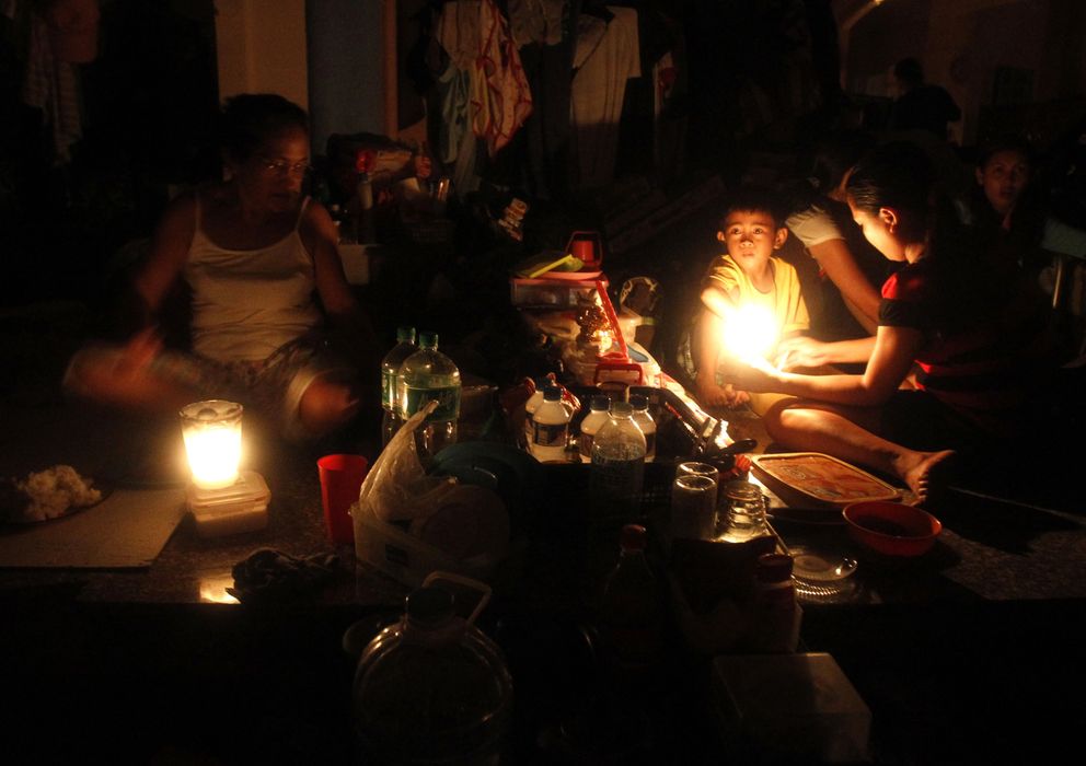 Foto: Supervivientes refugiados en una iglesia en el centro de Tacloban encienden un vela (Reuters).
