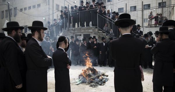 Foto: Varios judíos ultraortodoxos rezan mientras se procede a la quema de pan con levadura en el barrio de Mea Shearim en Jerusalén. (EFE)