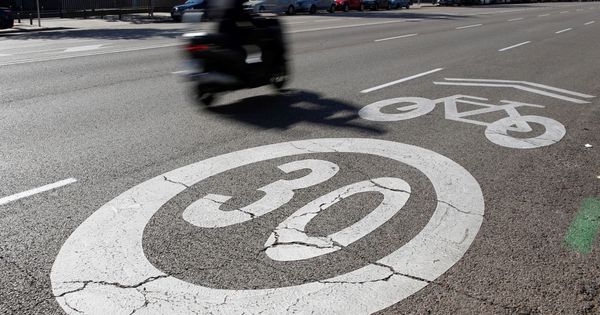 Foto: Una motocicleta circula por Madrid ante una señal de prohibido circular a más de 30 kilómetros por hora pintada en el suelo. (EFE)