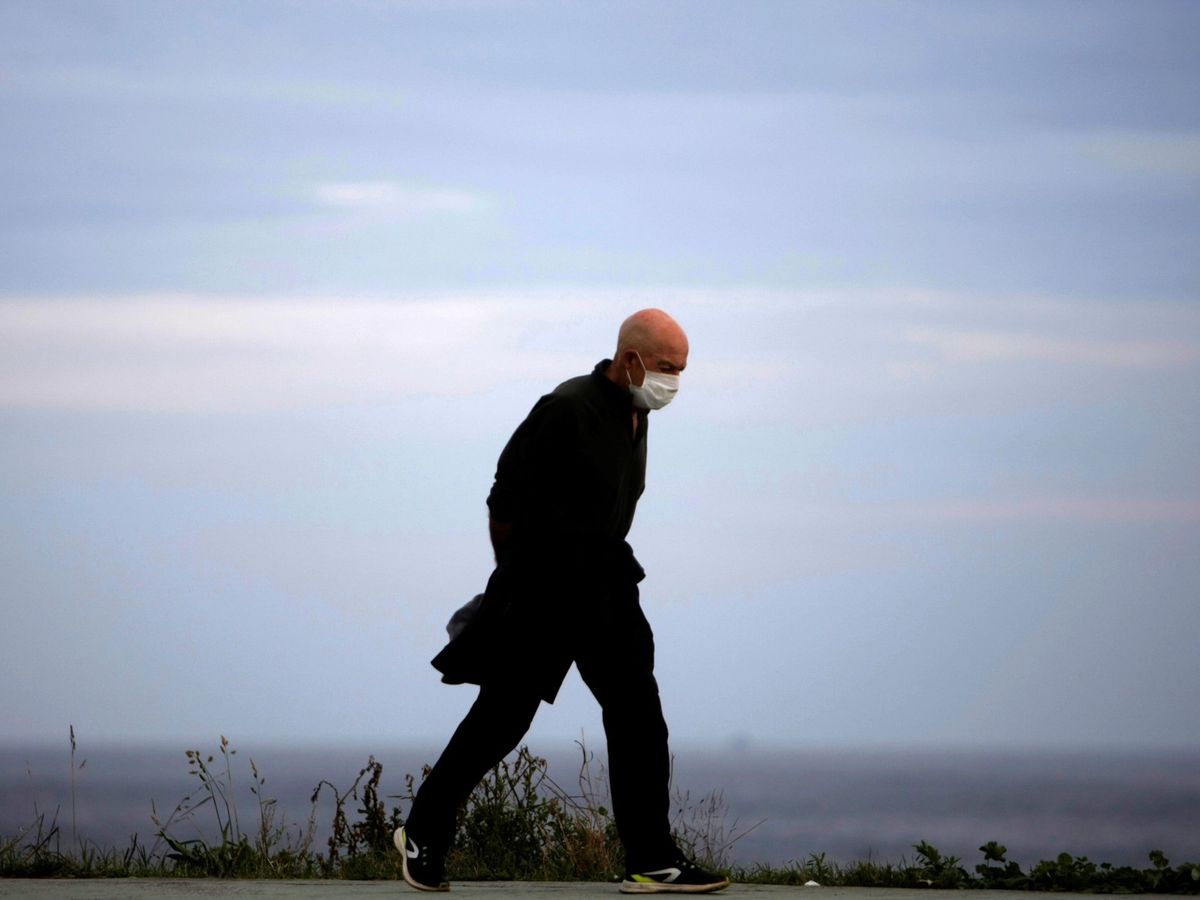 Foto: Un hombre camina solo por el paseo marítimo de A Coruña, en Galicia (EFE)