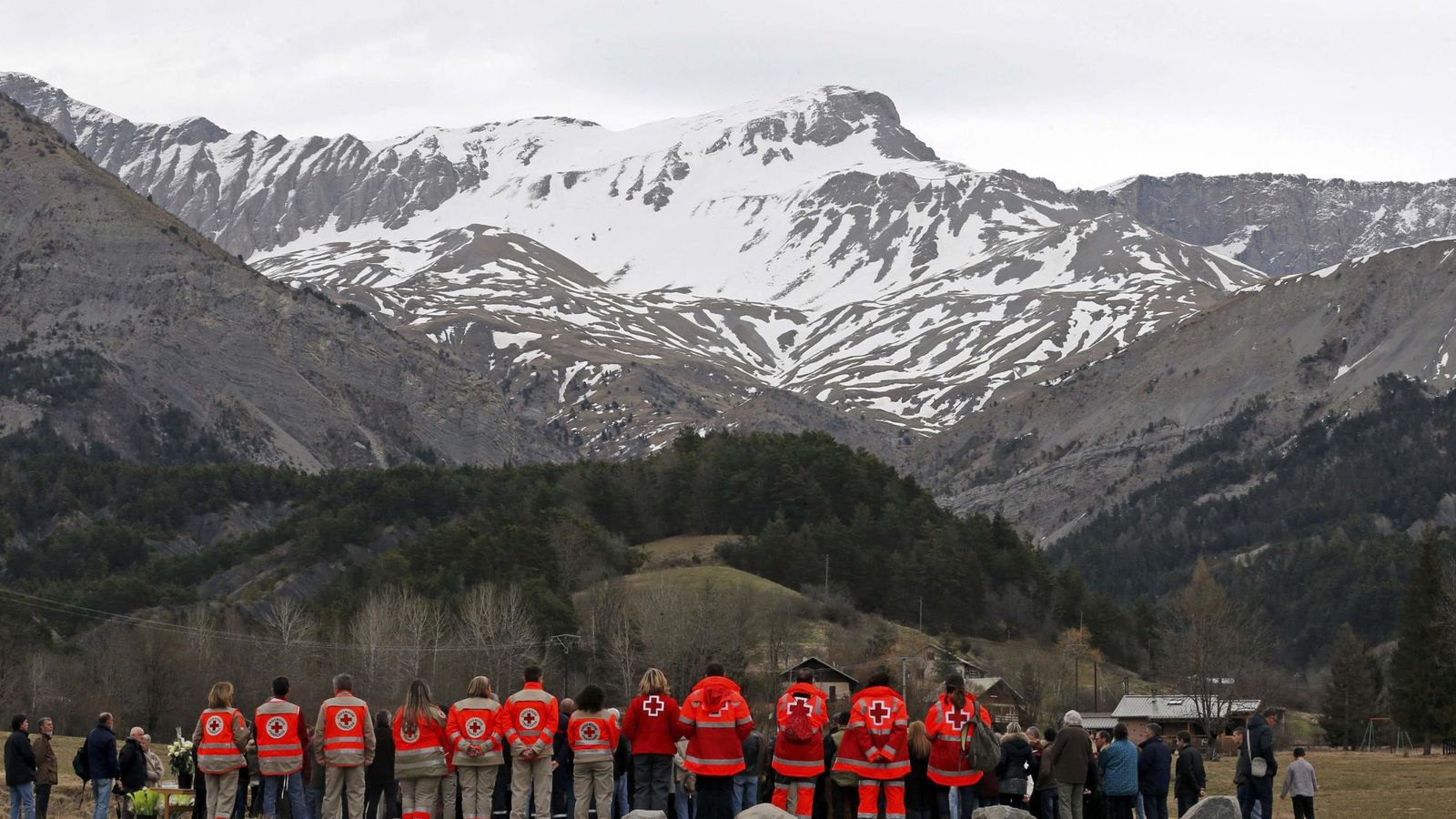 Foto: Personal de los equipos de rescate, ante el memorial por las víctimas en Le Vernet. (Reuters)