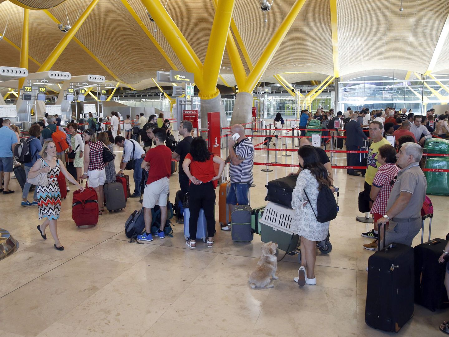 Viajeros esperan para facturar su equipaje en la T4 del aeropuerto de Barajas. (EFE)